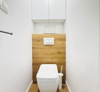 A bathroom in a 3-room apartment with flooring and tiles featuring a wood design.
