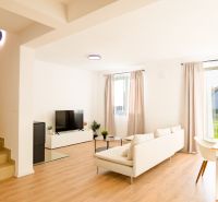 Bright living room of a family house with wood-decor flooring and comfortable seating.