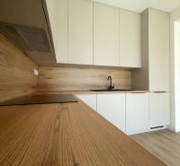 A kitchen in a family house with an elegant wooden decor floor and white cabinets.