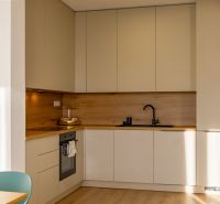 A kitchen in a family house with a wooden decor floor and minimalist design.