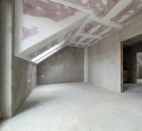 An attic room with an unfinished drywall ceiling construction in a family house.