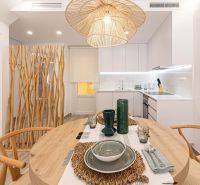 Dining area in a holiday apartment with wooden decorative elements and a ceiling light.