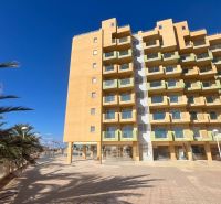 Recreational apartment in La Manga del Mar Menor with palm trees and a clear sky.