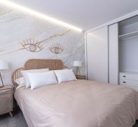 A recreational apartment with decorative elements, a double bed, and a wooden decor floor.