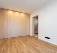 A room in a family house with a wooden decor floor and a built-in wardrobe.