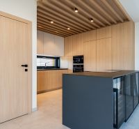 A kitchen in a family house with a wooden decor floor and modern lighting.