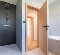 A stylish bathroom in a family house with a bathtub, shower, and tiles.
