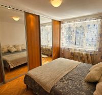 A bedroom with wardrobes with sliding doors and a large mirror in a 2-room apartment.