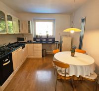 A bright kitchen in a 2-room apartment with a gas stove and a wooden decor floor.