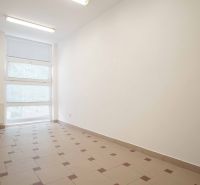 White office with tiles, large window, and radiator.