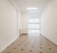 Office interior with a window and a radiator, tiled floor.