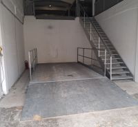 Warehouses and halls with a metal platform and staircase, white walls, industrial appearance.
