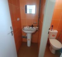 Orange-tiled toilets with a sink, mirror, and WC in commercial premises.