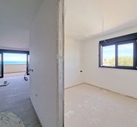 Partially finished interior of a 3-room apartment with a sea view, floor with wooden decor.