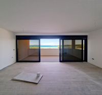 Living room of a three-room apartment with a glass wall and a floor with a wooden decor.