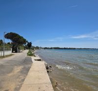 The coastal road in Privlaka runs along the sea in sunny weather.