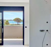 View from a 3-room apartment of the sea with trees and houses in Privlaka.
