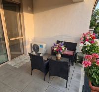 In the exterior of a 1-room apartment in Šoporňa, there is a terrace with seating and flowers.