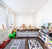 Children's room with toys and a bed, wooden decor flooring in a 3-room apartment.