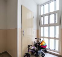 A hallway with a children's bicycle by the window and door in a 3-room apartment.