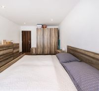 Bedroom in a 3-room apartment with wooden furniture and flooring with a wooden decor.