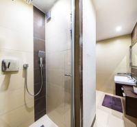 Bathroom with a shower, light tiles and a sink, 3-room apartment.