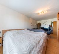 A bedroom in a 3-room apartment with a built-in wardrobe and flooring with a wood decor.