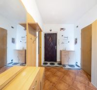 A hallway in a 3-room apartment with a wooden decor floor and a mirror.