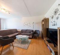 Living room with sofas, an armchair, a television, and a wooden decor floor in a 3-room apartment.
