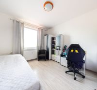 A bright room in a 3-room apartment with a wooden decor floor and a desk.