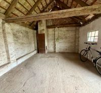 A spacious room in a family house with a bicycle and a wooden ceiling.
