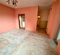 Room with orange walls and a concrete floor in a family house.