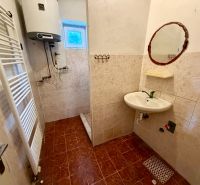 Bathroom in a family house with a tiled floor and a sink.