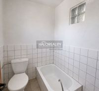 Bathroom in a family house with a bathtub, toilet, and white tiles.