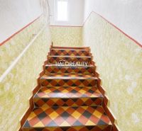 Interior of a family house with colorful tiles on the stairs and white walls.