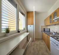 A kitchen with wooden decor and appliances, suitable for a studio apartment.