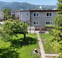 A family house in Martin with a spacious garden and mountains in the background.