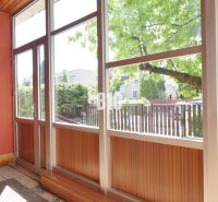 A glazed veranda with a view of the yard in a family house.