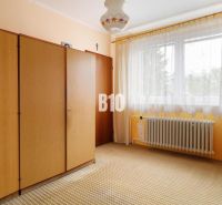 A room in a family house with a wardrobe, curtains, and a radiator.