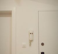 A white interior with an electrical panel and an intercom in a 4-room apartment.