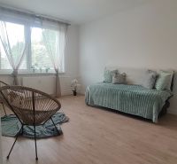 A room in a 4-room apartment with a wooden decor floor and light furniture.