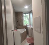 Bathroom with a shower and a bathtub in a 4-room apartment, light tiles and flooring.