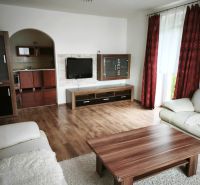 Living room in a family house with a sofa, table, and floor with a wooden decor.
