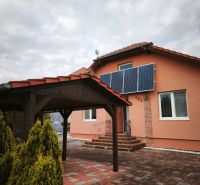 A family house in Martin nad Žitavou with solar panels and a gazebo on the terrace.