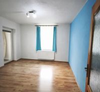 A room in a family house with a blue wall and a wooden decor floor.