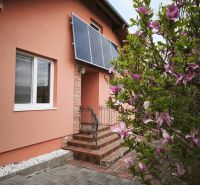 A family house on Hlavná Street in Martin nad Žitavou with solar panels and a magnolia.