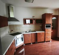 A kitchen with wooden decor, built-in appliances, and corner cabinets in a family house.