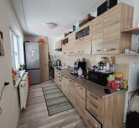 A kitchen with wooden decor in a 3-room apartment, equipped with appliances and storage space.