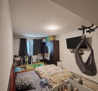 A children's room in a three-room apartment with a bed and a TV on the wall.