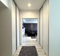 A hallway with built-in wardrobes and a floor with a wood decor in a 4-room apartment.